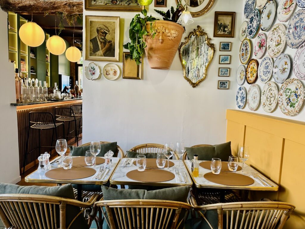 Girafe est un restaurant méditerranéen à Aix en Provence, situé sur la place des Cardeurs. Une bonne adresse pour déjeuner en terrasse ou boire un verre et profiter des festivités du weekend. (table et mur d'assiettes)