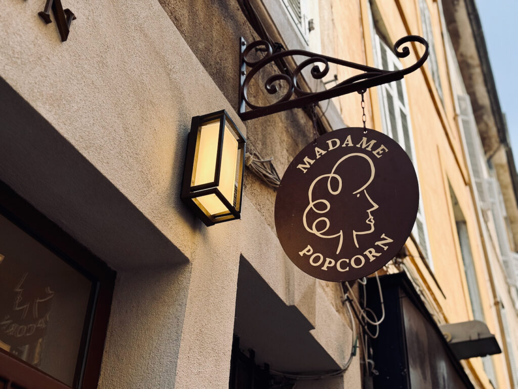 Madame Pop Corn est une boutique de pop corn située rue des Berradines à Aix-en-Provence. L'adresse propose des recettes artisanales, sucrées et salées, élaborées à partir de maïs du Gers sans OGM. (enseigne)
